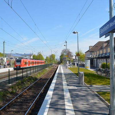 Das Foto zeigt den neu angelegten Bahnsteig für die Fahrrichtung Hannover. Links ist das Bahnhofsgebäude mit dem Fahrradunterstand zu sehen. Auf der linken Seite fährt gerade die S5 aus Hannover in den Bahnhof ein.