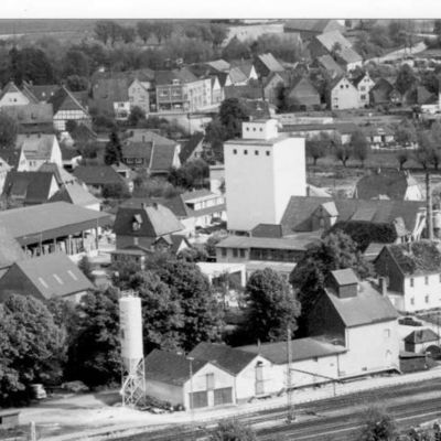 Das Fotoaus den 1960er Jahren zeigt aus der Vogelperspektive den nicht mehr vorhanden Güterbahnhof in Steinheim. Im Hintergrund sind der Kornspeicher der Bäuerlichen Genossenschaft und die Hallen der Möbelfabrik Schwertfeger zu sehen.